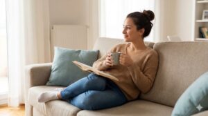 一人暮らしの部屋でリラックスして読書とコーヒーを楽しむ女性