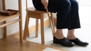 靴を履くためのスツールと使いやすい位置に配置された靴べらがある玄関の足元