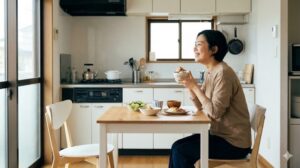 整った一人暮らしのキッチンで、笑顔で食事を楽しむ女性の幸せな様子