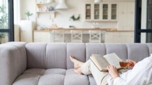 整った部屋でソファに座り読書をしてくつろぐ穏やかな時間