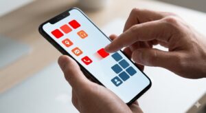 雑然とした画面から青系のアイコンがまとまり始め、赤いアイコンをドラッグして移動させている人差し指。